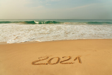 Sand beach with 2021 New Year symbol and blue waves, Sri Lanka