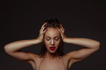 Lovely. Portrait of beautiful stylish woman isolated on dark studio background. Caucasian model with red lipstick, wet hair and shiny skin, bright make up. Beauty, fashion, emotions concept.