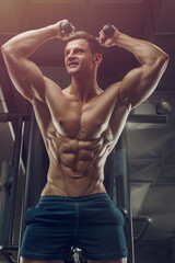 Bodybuilder strong man pumping up triceps muscles