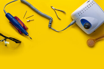 Top view of manicure and pedicure equipment on yellow background