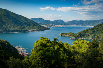 Fototapeta na wymiar A view from the hills between Turunc and Icmeler, Turkey looking toward Marmaris amid lush pine forested hills and azure blue sea.