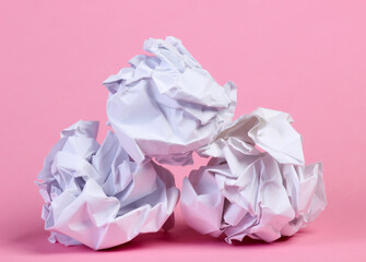 Crumpled paper balls on pink pastel background