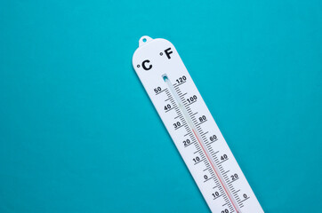 Weather thermometer on blue background. Climate control. Top view