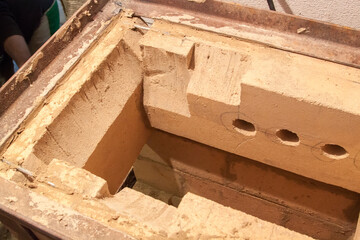 close up view of sauna stove that is being built from fire resistant material in undeveloped interior laid out of foam blocks in country house under construction