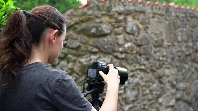 A young girl, a photographer, in a forest area, takes pictures of beautiful nature. Close-up.