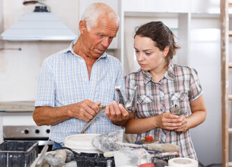 Woman and elderly father discussing installing faucet