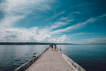 Back view of people walking down a jetty
