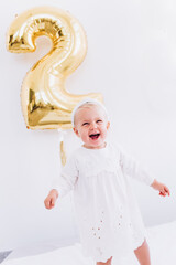 Birthday for a child. Baby girl in a white dress.
