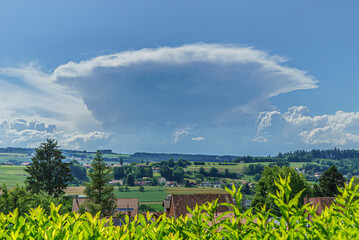 Magnifique cumulus en formation au-dessus du jura de forme conique au-dessus d'un paysage de la...