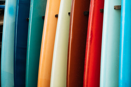 Set of colorful surfboard for rent on the beach. Multicolored blue, red, white surf boards different sizes and colors surfing boards on stand, surfboards rental place