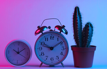 Cactus and alarm clocks in trendy neon light. Gradient pink-blue glow. Concept art. Minimalism
