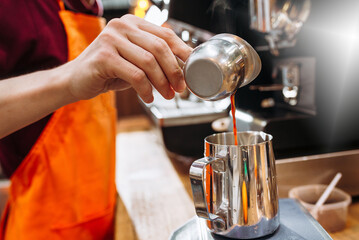 Fototapeta na wymiar cropped shot of barista preparing coffee in coffee maker. barista man pouring espresso into cup