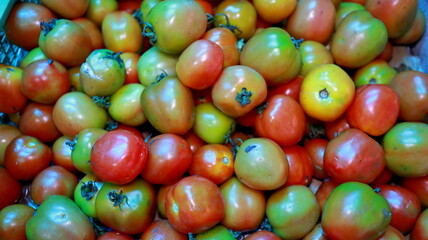 Overexposed and noise image Stack of tomatoes in basket for sale at farmer's market. Horizontal shot    