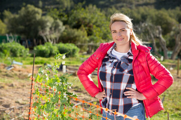 Female supervising growth of legume plants in garden