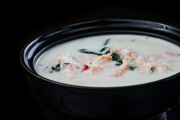 Japanese Soup With Chicken, Egg, Simeji Mushrooms and Eggplant On a Dark Background in a black plate. close up