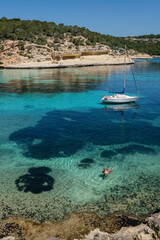 couple next to a moored sailboat, Cala Portals Vells, Calvia, Mallorca, Balearic Islands, Spain