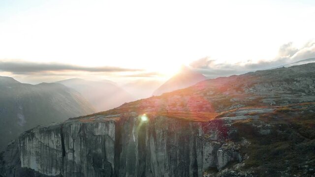Junger Mann l&auml;uft auf Gipfel im Sonnenuntergang in Norwegen, Abendwanderung in Norwegen, Drohnenshot