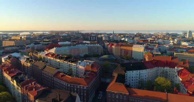 Aerial, drone shot over streets of Helsinki, towards the Temppeliaukio church, sunny spring sunrise, in Helsingfors, Finland