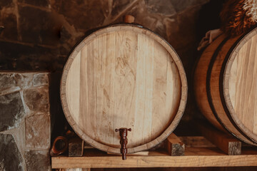 Vintage old oak barrels of wine, cognac in the wine dark vaults of the winery. Selective soft focus. Shooting in the dark