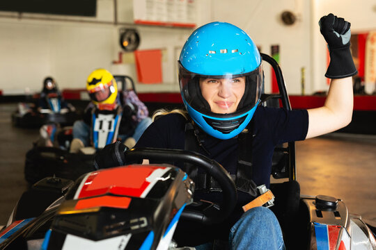 woman driving racing car at kart circuit