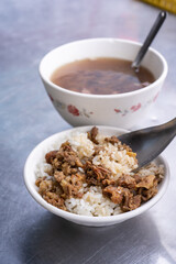 Braised meat rice, stewed beef over cooked rice in Tainan, Taiwan. Taiwanese famous traditional street food delicacy. Travel design concept, closeup.