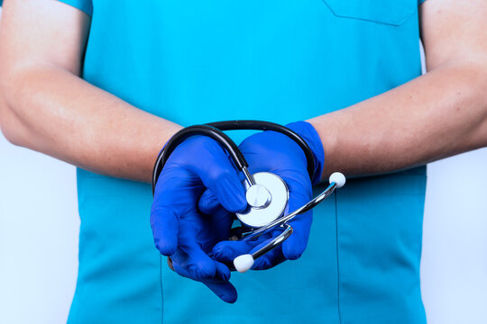 A Doctor In Blue Uniform With A Stethoscope Tied In His Hands. The Concept Of Obligations, Restrictions, Contracts, Crimes.