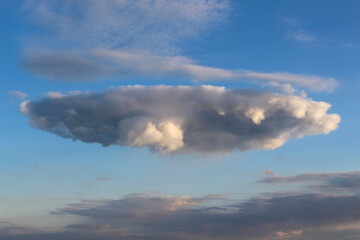Fototapeta na wymiar Niezwykłego kształtu chmura. Zachód słońca.