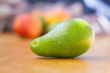 Avocado fuerte with fruits on the background, avocado in front of fruits horizontal photo natural light, healthy fruits on background