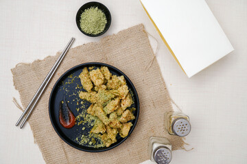 Delicious chiken chop with seaweed seasoning. Chicken chop on black plate.