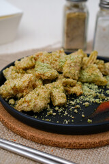 Delicious chiken chop with seaweed seasoning. Chicken chop on black plate.