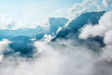 Fototapeta na wymiar Photo of atmospheric blue misty mountains with clouds in the sky
