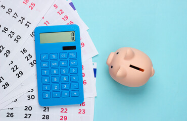 Piggy bank with a monthly calendar, calculator on a blue background. Payment of rental housing or...