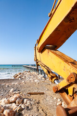 Scoop of an excavator set against a pier at the seafront in Argaka in Cyprus.