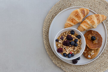 Topview image of yummy breakfast. Granola with berries, croissan