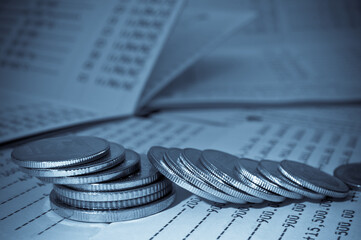 rows of coins on savings account passbook for finance and banking concept abstract blue background