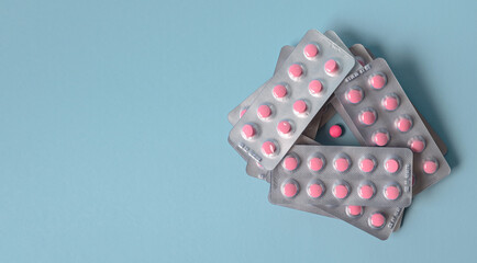 Pills pink in a pack on a blue background
