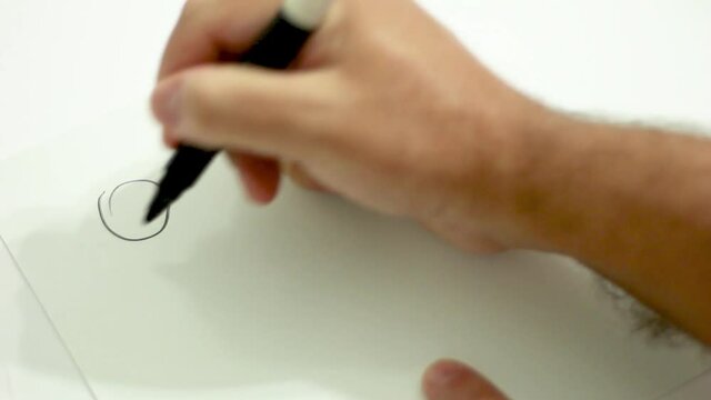 Hand writing with pen on white paper for people to stay home safe from coronavirus. Written in Spanish quedate en casa