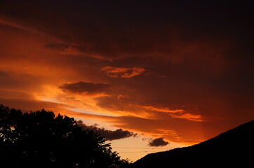 Golden sunset through wires over the roof of houses