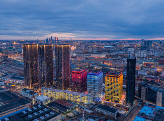Multi-colored skyscrapers on the background of the night city, aerial photo