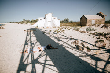 Young couple lying on the sea beach and kissing. The concept of love