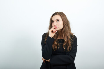 thinking about question, very confused idea hand under her chin making choice, young attractive woman brunette in in a black t-shirt and sweater on white background