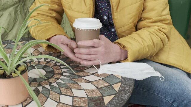 woman hands medical mask cafe cup coffee table to go yellow