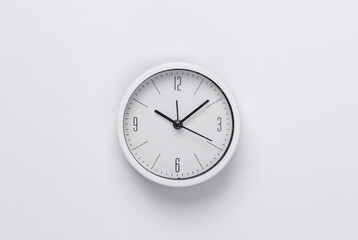White clock on white background. Minimalistic studio shot. Top view