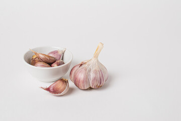 Whole head and cloves of purple garlic on a white background. Isolate, copy space