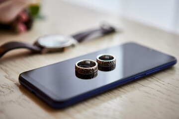 Wedding rings lie on the phone. Different accessories of businessman for creating style of  people...