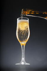Champagne pouring into glass on black background