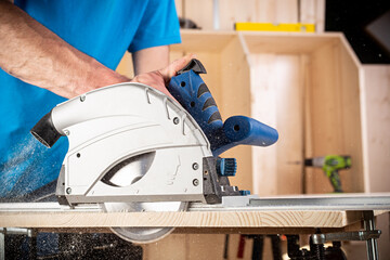 carpenter with hand circular saw at work. closeup of sawing cut of pine wood woodworking construction tool concept furniture making diy background