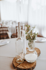 Wedding, decor on the table, candles are burning, a bouquet of flowers. Rustic wood background...