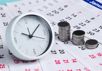 Fototapeta na wymiar Clock with a stack of coins on a monthly calendar. Time is money. Time to invest