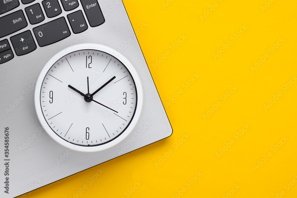 Poster laptop and alarm clock on yellow background. time running away. the concept of urgent deadlines at w